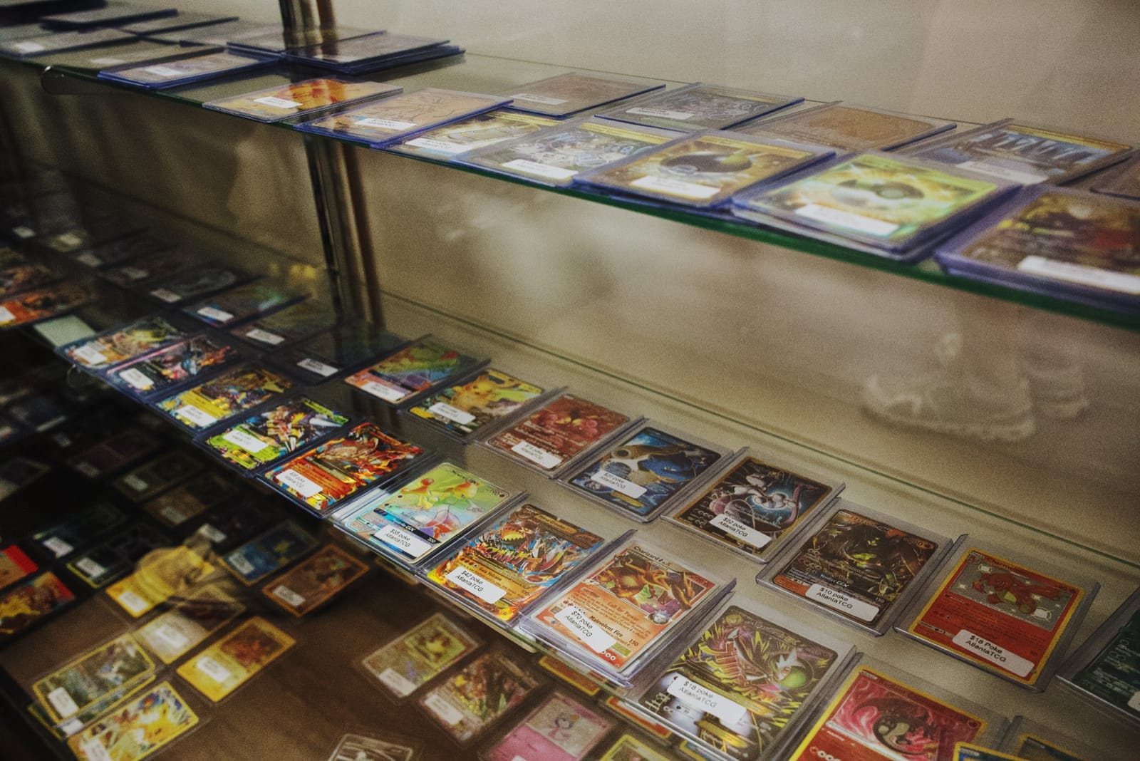 AtlantaTCG display cases lined with graded slabs and chase singles