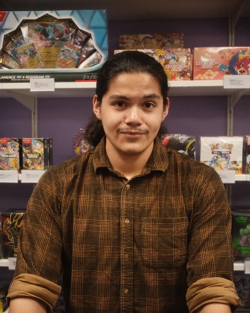 Devin in front of shelves stocked with sealed Pokémon product