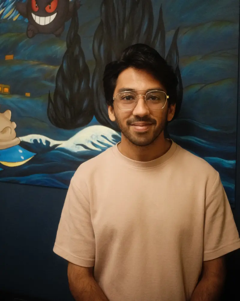 Hashim in front of the shop's Starry Night Pokémon mural